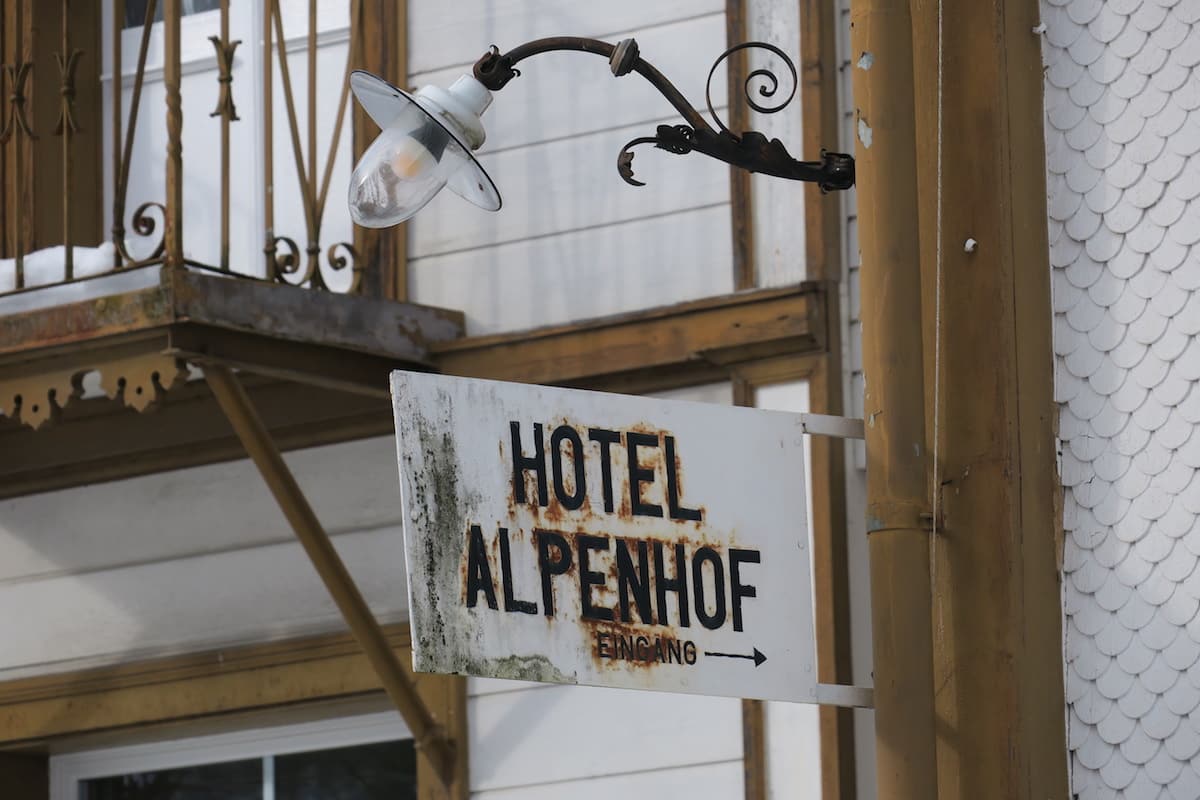 Eingangsschild und Aussenlampe des Hotel Alpenhof in Weisstannen